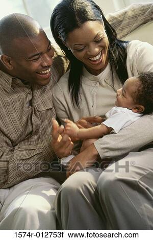 Stock Image - Close-up of parents holding their son. Fotosearch