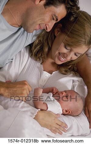 Stock Image - Close-up of parents looking at their son and smiling. Fotosearch