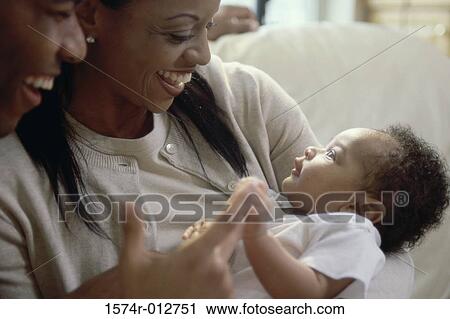 Close-up of parents looking at their son and smiling View Large Photo Image Stock Image - Close-up of parents looking at their son and smiling. Fotosearch