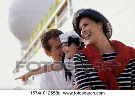 Stock Image - Close-up of parents standing with their daughter on a cruise ship. Fotosearch