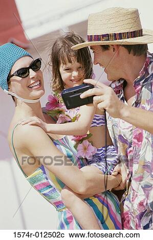 Close-up of parents with their daughter taking a photograph of themselves View Large Photo Image Stock Image - Close-up of parents with their daughter taking a photograph of themselves. Fotosearch