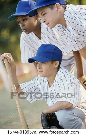 Stock Image - Close-up of three baseball players with a baseball bat. Fotosearch