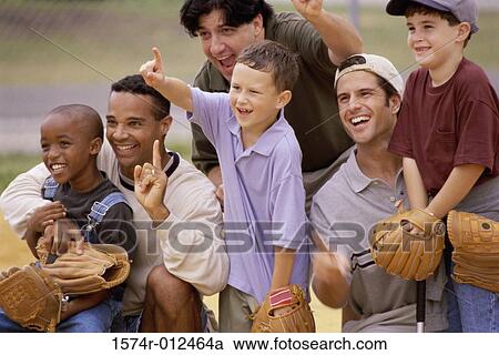 Stock Image - Close-up of three fathers with their sons wearing baseball gloves in a baseball field. Fotosearch