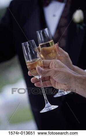 Close-up of two people's hand holding champagne flutes View Large Photo Image Stock Image - Close-up of two people's hand holding champagne flutes. Fotosearch