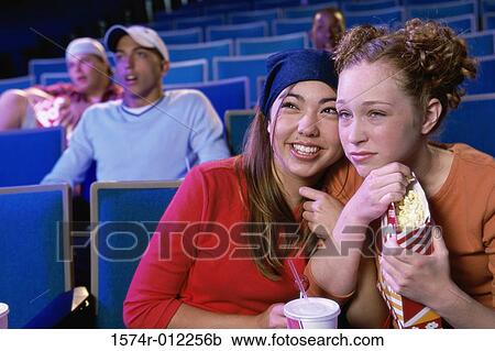 Close-up of two teenage girls sitting in a movie theater View Large Photo Image Stock Image - Close-up of two teenage girls sitting in a movie theater. Fotosearch