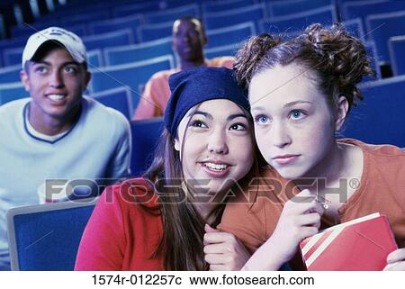 Close-up of two teenage girls sitting in a movie theater View Large Photo Image Stock Image - Close-up of two teenage girls sitting in a movie theater. Fotosearch