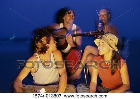 Close-up of two young couples on the beach at night View Large Photo Image Stock Photo - Close-up of two young couples on the beach at night. Fotosearch