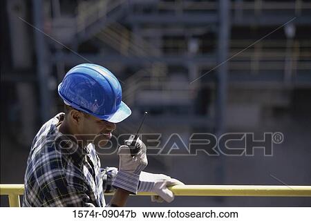 Construction worker talking on a walkie-talkie View Large Photo Image Stock Image - Construction worker talking on a walkie-talkie. Fotosearch