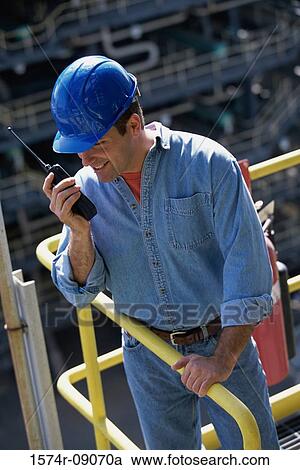Stock Image - Construction worker talking on a walkie-talkie. Fotosearch