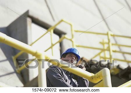 Construction worker talking on a walkie-talkie View Large Photo Image Stock Image - Construction worker talking on a walkie-talkie. Fotosearch