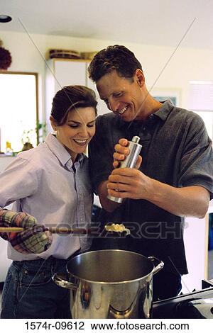 Couple cooking together in a kitchen View Large Photo Image Stock Image - Couple cooking together in a kitchen. Fotosearch