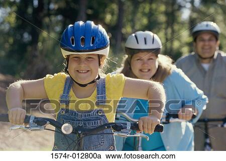 Stock Image - Daughter cycling with her parents. Fotosearch