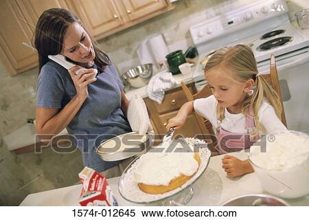 Daughter helping her mother bake a cake View Large Photo Image Stock Photography - Daughter helping her mother bake a cake. Fotosearch