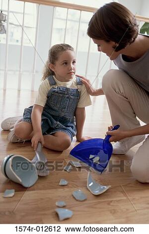 Daughter helping her mother sweep the pieces of broken crockery off the floor View Large Photo Image Stock Image - Daughter helping her mother sweep the pieces of broken crockery off the floor. Fotosearch