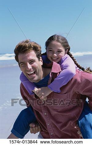 Picture - Daughter riding piggyback on her father. Fotosearch