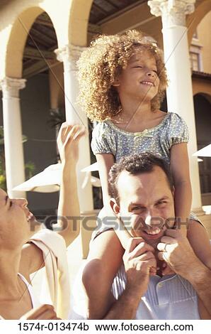 Daughter sitting on her father's shoulders View Large Photo Image Stock Image - Daughter sitting on her father's shoulders. Fotosearch