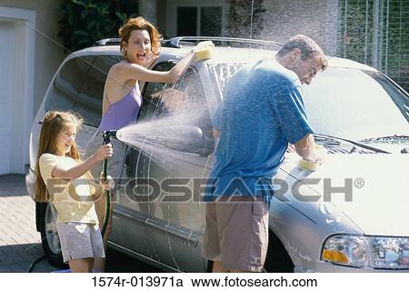 Daughter spraying water on her father with her mother washing the car View Large Photo Image Stock Image - Daughter spraying water on her father with her mother washing the car. Fotosearch