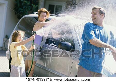 Daughter spraying water on her father with her mother washing the car View Large Photo Image Stock Image - Daughter spraying water on her father with her mother washing the car. Fotosearch