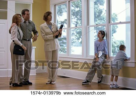 Estate agent showing a family a house View Large Photo Image Stock Image - Estate agent showing a family a house. Fotosearch