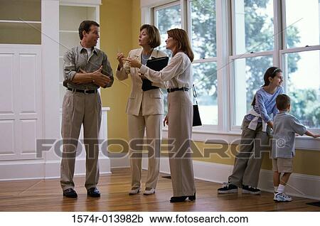 Estate agent showing a family a house View Large Photo Image Stock Image - Estate agent showing a family a house. Fotosearch