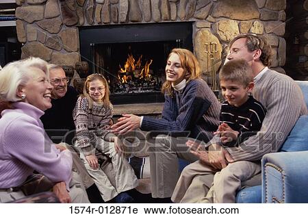 Family sitting near the fireplace in a living room View Large Photo Image Stock Image - Family sitting near the fireplace in a living room. Fotosearch