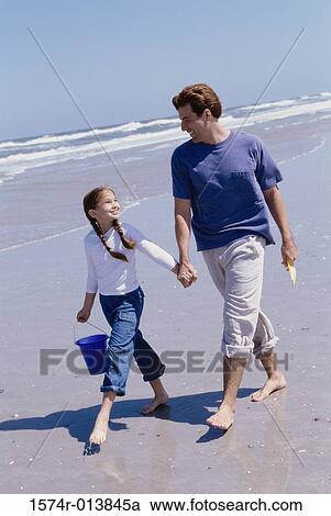 Father and daughter walking on the beach View Large Photo Image Stock Image - Father and daughter walking on the beach. Fotosearch