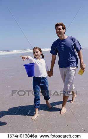 Father and daughter walking on the beach View Large Photo Image Stock Image - Father and daughter walking on the beach. Fotosearch
