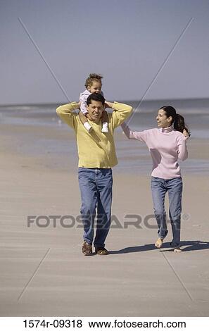 Father and mother on the beach carrying their daughter View Large Photo Image Stock Photo - Father and mother on the beach carrying their daughter. Fotosearch