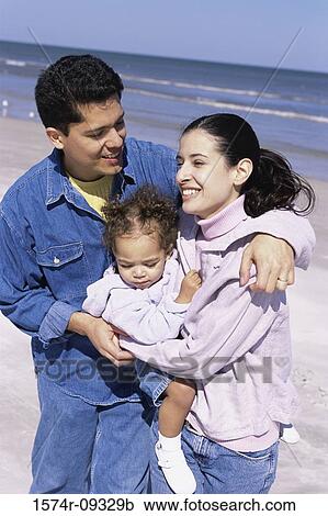 Father and mother on the beach holding their daughter View Large Photo Image Stock Image - Father and mother on the beach holding their daughter. Fotosearch