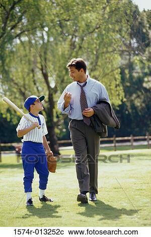 Father and son walking in a park View Large Photo Image Stock Image - Father and son walking in a park. Fotosearch