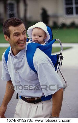 Stock Image - Father carrying his baby girl on his back. Fotosearch