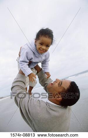 Father carrying his daughter on the beach View Large Photo Image Stock Image - Father carrying his daughter on the beach. Fotosearch