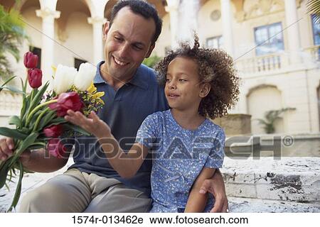 Father holding a bouquet of flowers with his daughter View Large Photo Image Stock Image - Father holding a bouquet of flowers with his daughter. Fotosearch