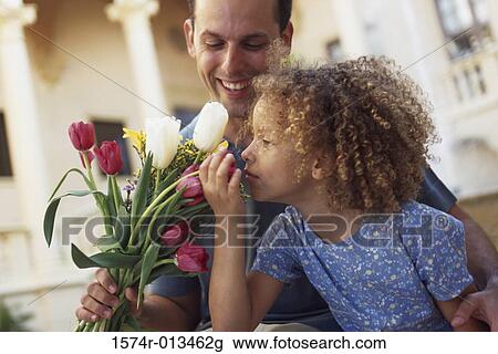 Father holding a bouquet of flowers with his daughter View Large Photo Image Stock Image - Father holding a bouquet of flowers with his daughter. Fotosearch