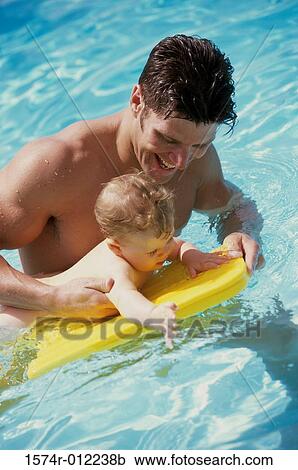 Stock Image - Father in a swimming pool with his baby boy. Fotosearch