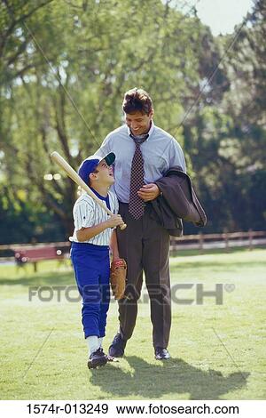 Stock Photo - Father walking in the park with his son carrying a baseball bat. Fotosearch
