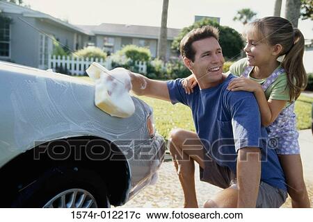 Father washing his car with his daughter leaning on him View Large Photo Image Stock Image - Father washing his car with his daughter leaning on him. Fotosearch
