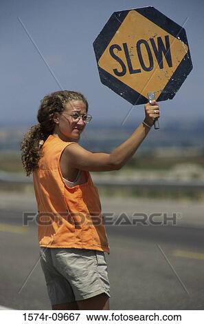 Stock Photo - Female construction worker holding a warning sign. Fotosearch