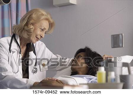 Stock Image - Female doctor talking to a female patient. Fotosearch