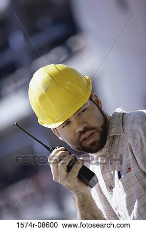 Foreman talking on a walkie-talkie View Large Photo Image Stock Image - Foreman talking on a walkie-talkie. Fotosearch