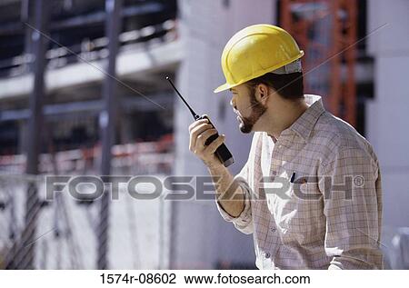 Foreman talking on a walkie-talkie View Large Photo Image Stock Image - Foreman talking on a walkie-talkie. Fotosearch