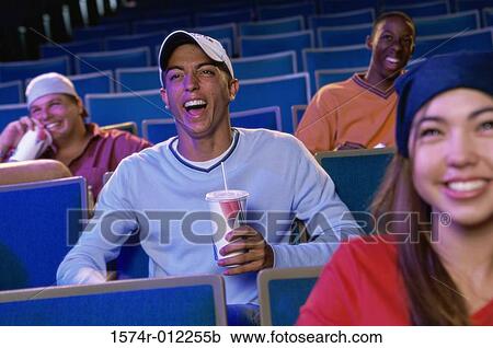 Stock Image - Four teenagers sitting in a movie theater. Fotosearch