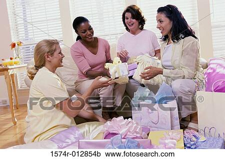 Stock Image - Four women opening gifts at a baby shower. Fotosearch