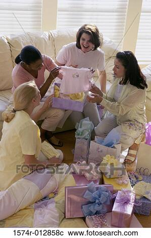 Four women opening gifts at a baby shower View Large Photo Image Stock Image - Four women opening gifts at a baby shower. Fotosearch