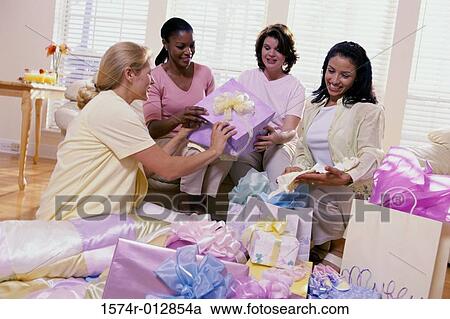 Stock Image - Four young women sitting together at a baby shower. Fotosearch
