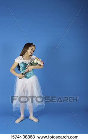 Girl in a ballerina outfit holding a bouquet of flowers View Large Photo Image Stock Photo - Girl in a ballerina outfit holding a bouquet of flowers. Fotosearch