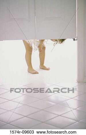 Girl peeking from under a swinging door View Large Photo Image Stock Image - Girl peeking from under a swinging door. Fotosearch