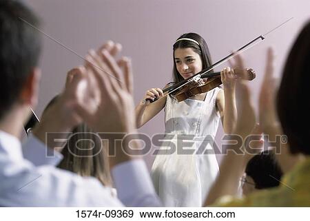 Girl playing a violin in front of an audience View Large Photo Image Stock Photo - Girl playing a violin in front of an audience. Fotosearch