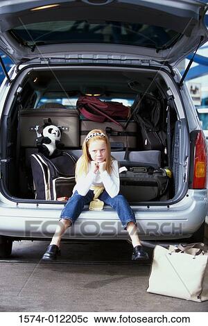 Stock Image - Girl sitting in the back of a car. Fotosearch