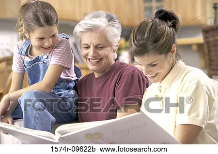 Girl with her mother and grandmother looking at a photo album View Large Photo Image Stock Image - Girl with her mother and grandmother looking at a photo album. Fotosearch
